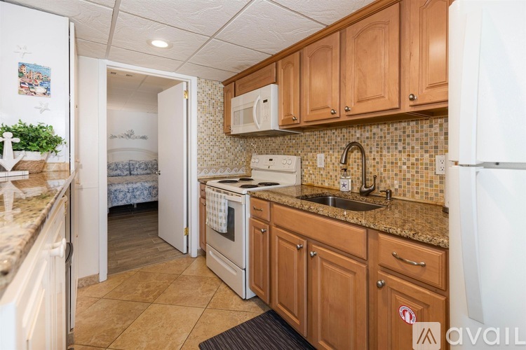 A kitchen with wooden cabinets and a white refrigerator.