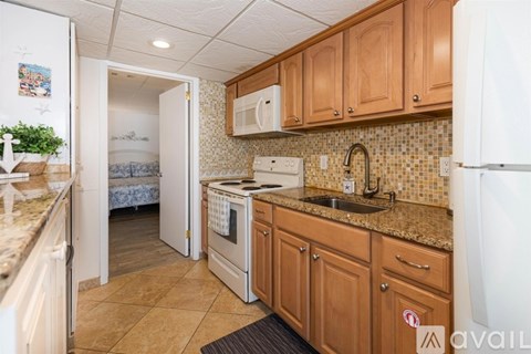 A kitchen with wooden cabinets and a white refrigerator.