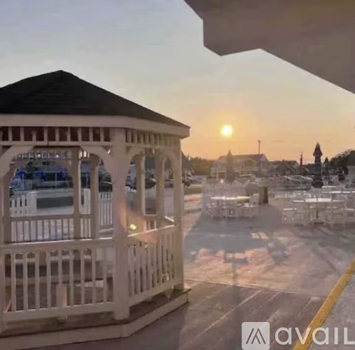 A gazebo is in the foreground with a sunset in the background.