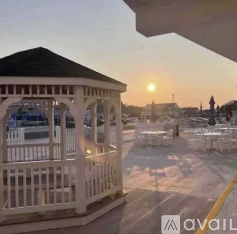 A gazebo is in the foreground with a sunset in the background.
