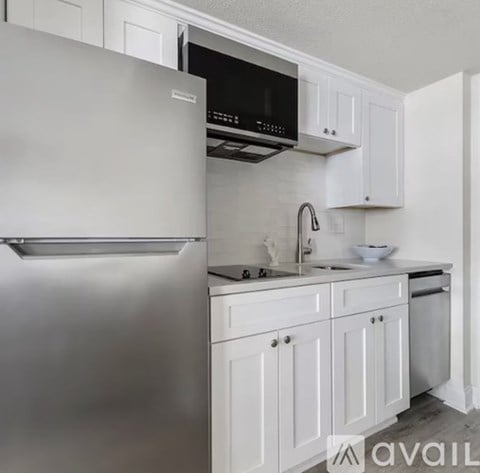 A modern kitchen with white cabinets and stainless steel appliances.