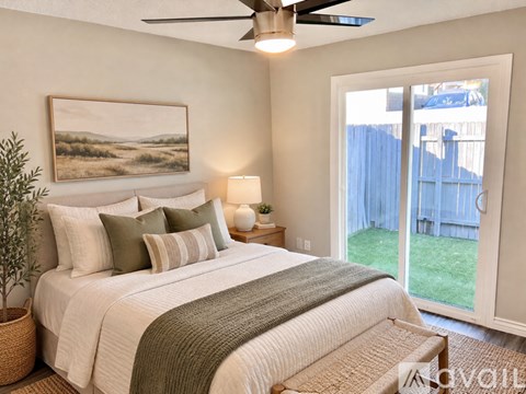 A bedroom with a large bed and a painting on the wall.