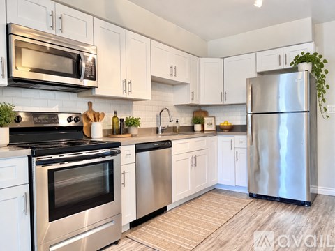 A modern kitchen with stainless steel appliances and white cabinets.