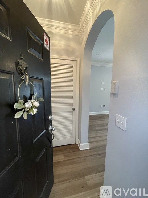 A black door with a flower decoration on it.