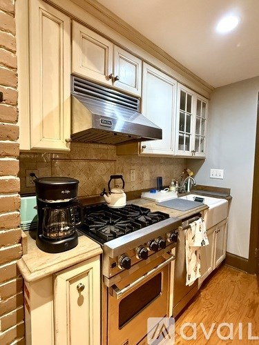 A kitchen with a stove top oven and a coffee maker.