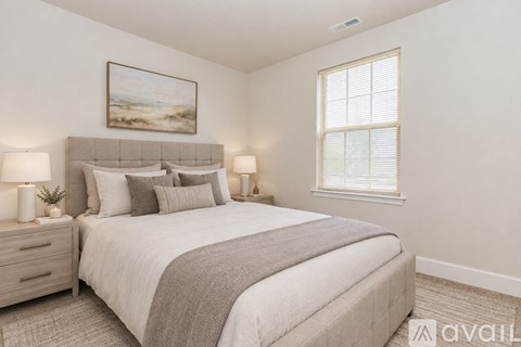 A bedroom with a large bed, two nightstands, and a painting on the wall.
