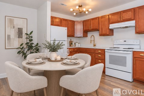A kitchen with a white dishwasher and white oven with brown cabinets.