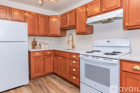 A kitchen with wooden cabinets and a white refrigerator.