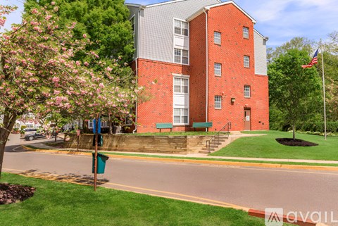 A red brick building with a green lawn in front.