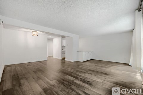 A room with wooden flooring and white walls.