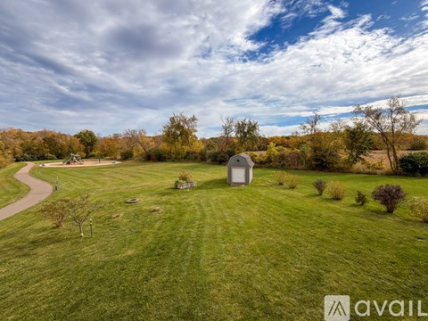 A grassy field with a small building and a winding path.