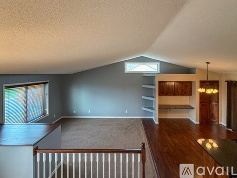 A spacious living room with a staircase leading to the upper level.