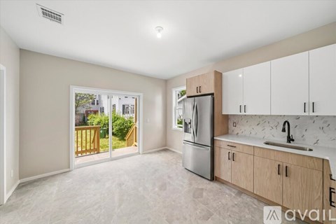 A kitchen with a refrigerator, sink, and cabinets is available for rent.
