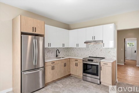A kitchen with a refrigerator, oven, and sink.