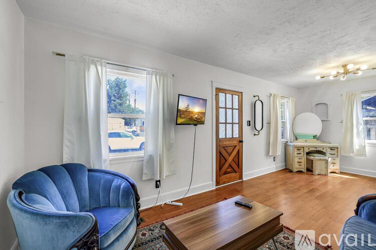 A living room with a blue chair and a wooden coffee table.
