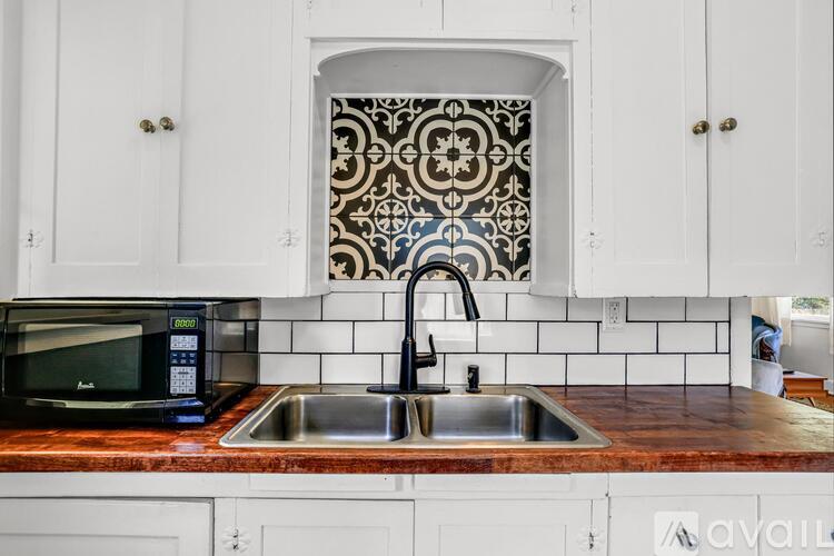 A kitchen with a sink and a microwave.