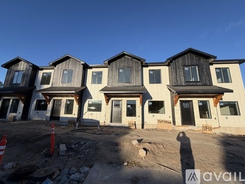 A row of houses under construction with a clear blue sky.