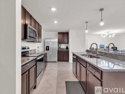 A kitchen with brown cabinets and a marble countertop.