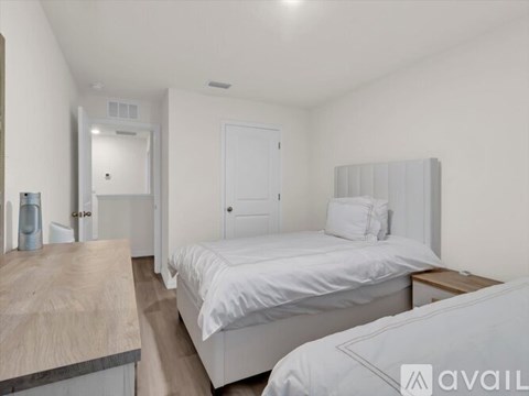 A bedroom with a bed, nightstand, and a wooden counter.