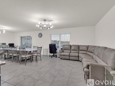 A living room with a grey sofa and chairs.