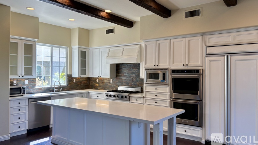 A modern kitchen with a large island and stainless steel appliances.
