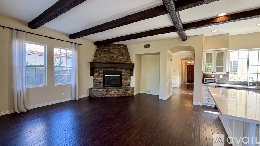 A spacious living room with a fireplace and hardwood floors.