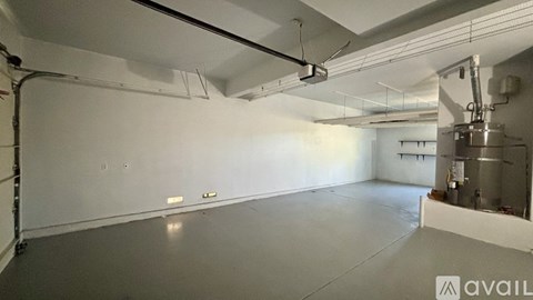 A large, empty industrial space with a concrete floor and white walls.