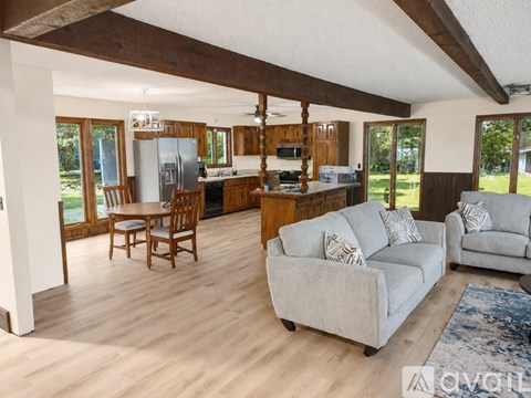 A living room with a grey couch and wooden floors.