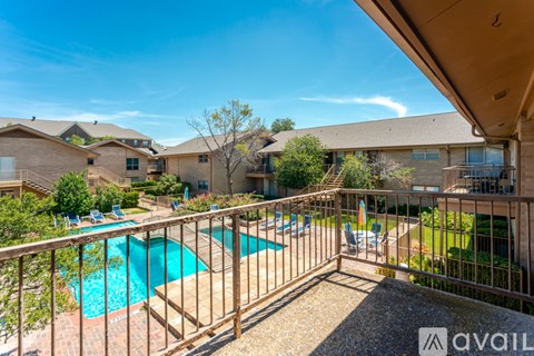 A pool surrounded by a fence and a patio area.