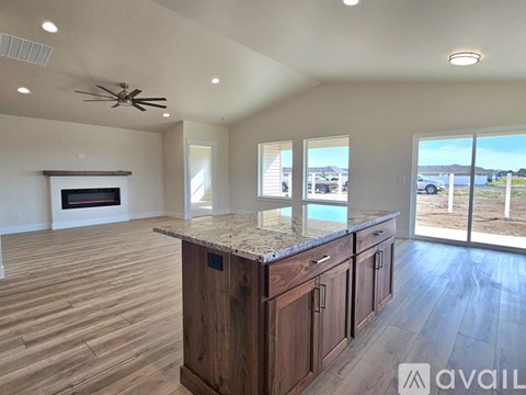 A spacious kitchen with wooden cabinets and a marble countertop.