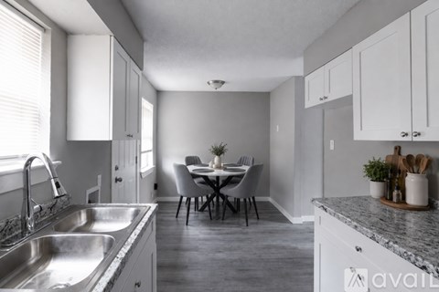 A kitchen with a dining table and chairs in the middle of the room.