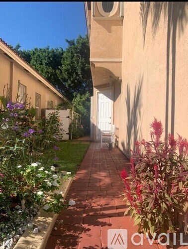 A garden pathway with a white door in the background.