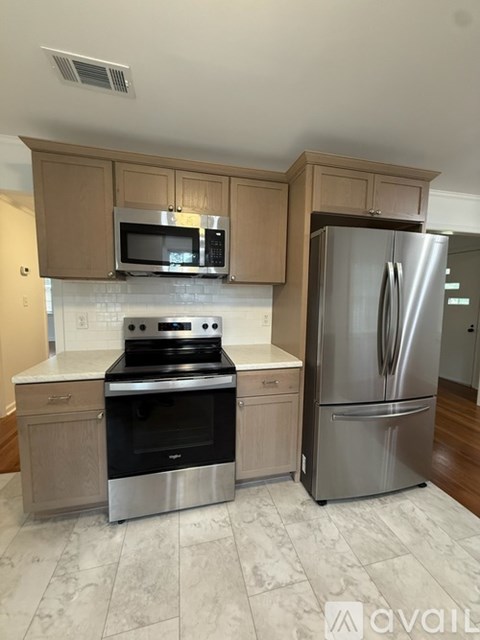 A kitchen with a stove, oven, refrigerator and microwave.