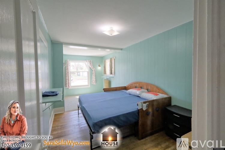A bedroom with a bed, dresser, and window.