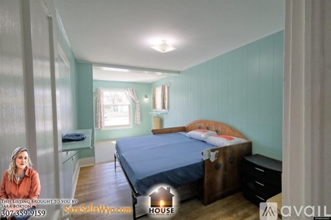A bedroom with a bed, dresser, and window.