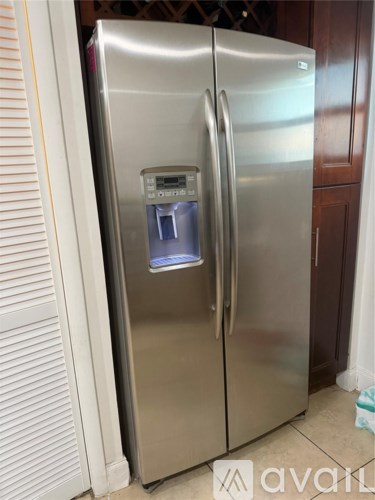 A stainless steel refrigerator with a water and ice dispenser in the door.