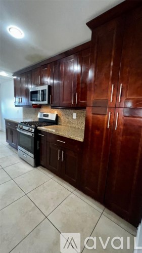 A kitchen with brown cabinets and a tile floor.