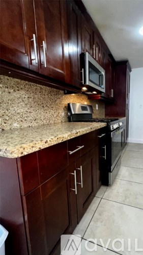 A kitchen with brown cabinets and a granite countertop.