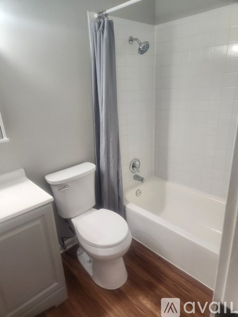A white toilet sits next to a bathtub in a bathroom.