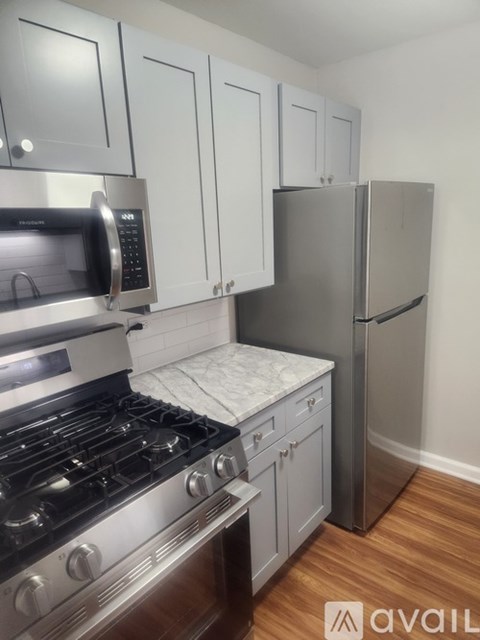 A kitchen with a stove, oven, microwave, and refrigerator.