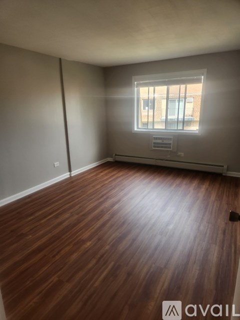 A room with wooden flooring and a window.