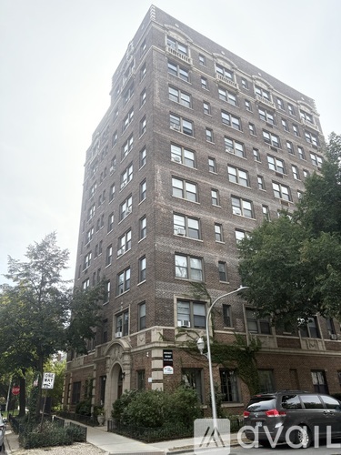A tall building with many windows and a sign on the front.