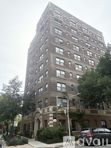 A tall building with many windows and a sign on the front.