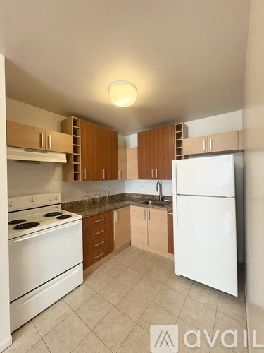 A kitchen with white appliances and wooden cabinets.