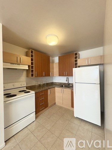 A kitchen with white appliances and wooden cabinets.