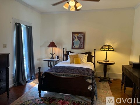 A bedroom with a large bed and a ceiling fan.