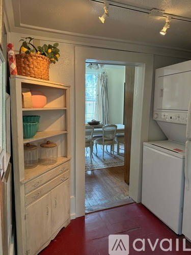 A kitchen with a white refrigerator and a basket of lemons on the counter.