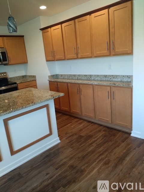 A kitchen with wooden cabinets and a granite countertop.