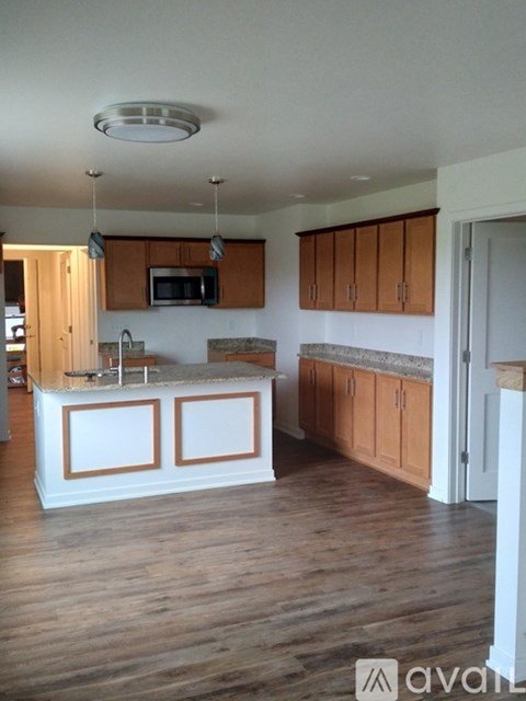 A kitchen with wooden cabinets and a white island.