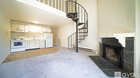 A living room with a spiral staircase leading to the upper floor.